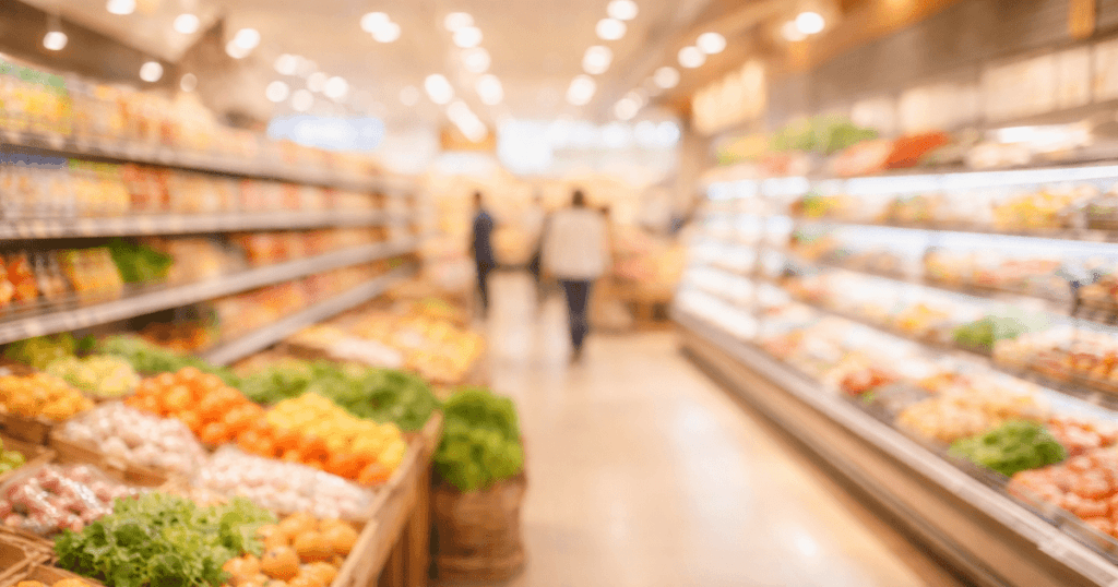 スーパーの棚や照明が少しぼんやり見え、刺激の多さが伝わるやわらかいイメージ