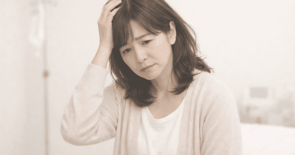 病院で検査を受けたあと、少し不安そうに座っている女性